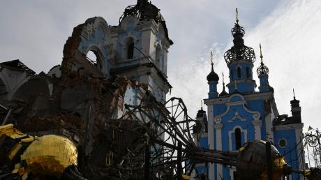 Zerstörte Kuppeln liegen neben einer beschädigten Kirche in einem zurückeroberten Dorf in der Ostukraine. 
