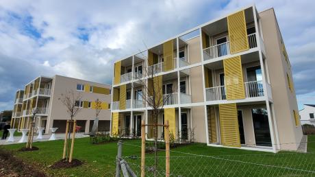 Zwei cremefarbige Häuser mit leuchtend gelben Details bieten in 17 Wohnungen Platz für Menschen mit schmalem Geldbeutel.