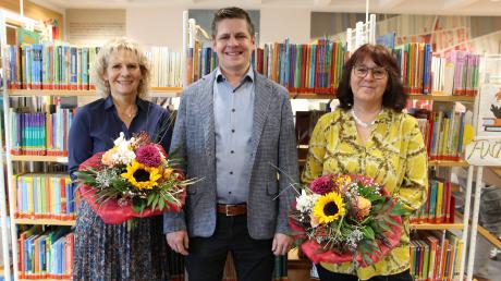 Zweiter Bürgermeister Max Schuler überreichte Blumen an Büchereileiterin Elke Popp (rechts) und Mitarbeiterin Corina Nerlinger (links) – beide sind seit der Eröffnung im Jahr 2002 mit dabei. Nicht im Bild sind die beiden weiteren Mitarbeiterinnen der Bücherei, Traudl Egger und Birgit Schramm.
