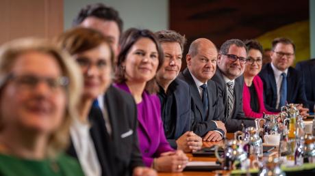 Bundeskanzler Olaf Scholz (vierter von rechts) sitzt beim traditionellen Gruppenbild vor der Sitzung des Bundeskabinetts im Kanzleramt zwischen seinen Kabinettsmitgliedern.