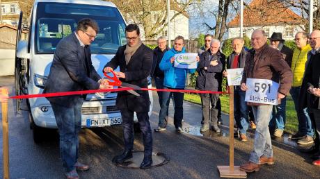 Bürgermeister Joachim Eisenkolb (links) und Achim Merkle vom Busunternehmen SVL durchschneiden das rote Band vor dem Ortsbus.