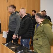Drei Männer stehen vor dem Landgericht Augsburg. Es geht um den brutalen Überfall auf ein älteres Ehepaar in Bergheim.