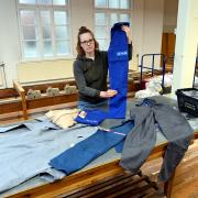 Mirjam Frank zeigt Arbeitskleidung der Augsburger Traditionsfirma EFA, die aufgelöst werden muss.                        