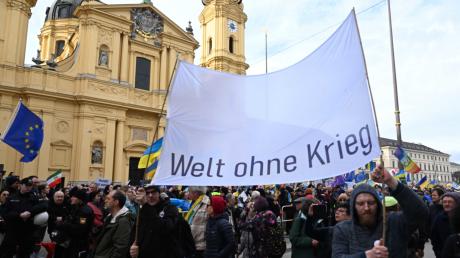Demonstranten laufen mit Bannern mit der Aufschrift "Welt ohne Krieg" über den Odeonsplatz. Die 59. Münchner Sicherheitskonferenz (MSC) findet vom 17. bis zum 19. Februar 2023 im Hotel Bayerischer Hof in München statt. 