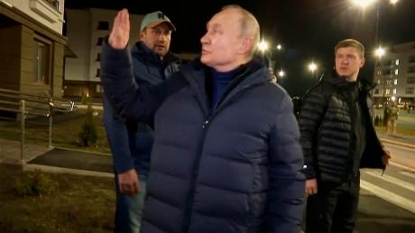 Auf diesem von einem russischen Fernsehsender am 19.03.2023 veröffentlichten Videostandbild winkt Wladimir Putin, Präsident von Russland, Anwohnern zu.