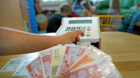 Ein Kind spielt mit Spielgeld – mehr echtes Geld müssen Eltern ab dem Herbst für die Kinderbetreuung in Buch bezahlen.