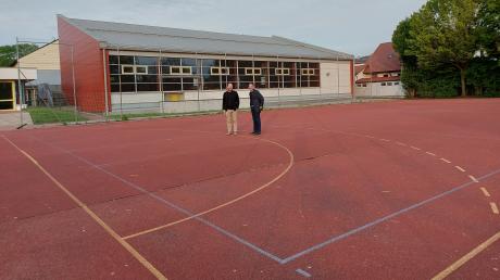Auf dem Hartplatz an der Affinger Grundschule werden bald Klassen in Containern unterrichtet. Architekt Alen Jasarevic (links) und Schulleiter Karsten Weigl begutachten das Terrain.