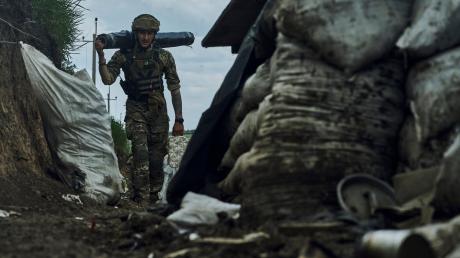 Ein ukrainischer Soldat trägt Vorräte in einem Graben an der Frontlinie bei Bachmut. Diese Schlacht ist für die Ukraine verloren. 