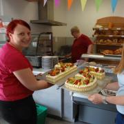Die Schwestern Kathrin und Lisa präsentieren ihre selbst gebackene Torte mit der Jubiläumszahl 15 zum Jubiläum des Lauterbacher Dorfladens.