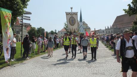 Einzug der Pilgerinnen und Pilger nach Altötting mit Fahnen und Kreuzen über den Kapellplatz zur Basilika.