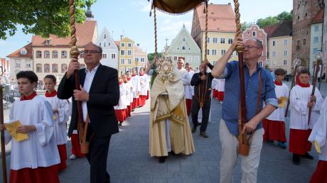 Bei der Fronleichnamsprozession in Landsberg trägt der Geistliche die Monstranz unter einem Baldachin. 