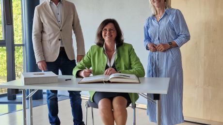 Landtagspräsidentin Ilse Aigner (m.) mit Carolina Trautner, und Wehringens 2. Bürgermeister Max Schuler beim Eintrag ins Goldene Buch.
