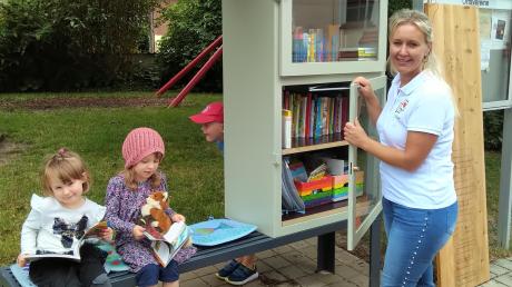 Marleen, Mia und Felix (versteckt) testen die neue Bücherbox am Allmannshofer  Bürgerhaus. Vorsitzende Vanessa Eckstein hat mit ihrem Verein Dorferleben Allmannshofen und mit der IBA den Tausch-Schrank möglich gemacht.