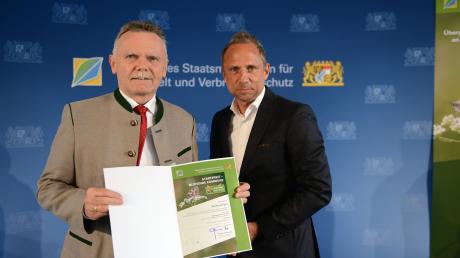Wiedergeltingens Bürgermeister Norbert Führer nimmt die Urkunde vom Staatsminister Thorsten Glauber in Empfang.