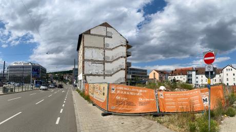 Das einzelne Wohnhaus steht noch, die Bauzäune mit Müller-Werbung stehen schon: Auf der Brachfläche ist ein Gebäudekomplex geplant.