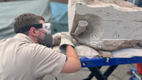 Mit einem Druckluftstichel bearbeitet Frederik Spindler im Dinomuseum Denkendorf einen Sandsteinblock, in dem sich Knochen eines Riesenlurchs verbergen.