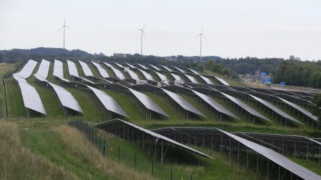 Seit rund zehn Jahren wird im Wittelsbacher Land mehr Strom regenerativ erzeugt als verbraucht. Das Bild zeigt den Solarpark an der Autobahn A8, der in Fahrtrichtung Stuttgart kurz vor der Ausfahrt Dasing zu sehen ist. Im Hintergrund drei der Windräder im Blumenthaler Forst.
