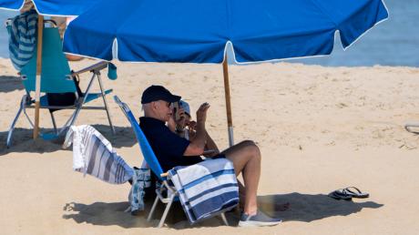 Joe Biden und seine Frau Jill sitzen unter einem Sonnenschirm am Strand von Rehoboth Beach.