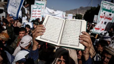Wütende Moslems halten Plakate und ein Exemplar des Koran in die Höhe. Sie protestieren gegen die Verbrennung des Buches in Schweden.  