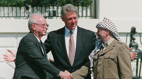 Berühmter Handschlag: Der israelische Ministerpräsident Izchak Rabin und der Vorsitzende der Palästinensischen Befreiungsorganisation PLO Jassir Arafat mit US-Präsident Bill Clinton am 13. September 1993 in Washington. 