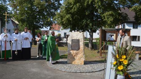Pater Thomas Madavana (links) segnet den neu aufgestellten Gedenkstein für den vor sieben Jahren verstorbenen Pfarrer Hans Sing.