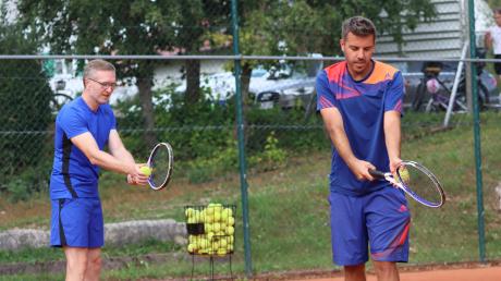 Tennistrainer Stefan Gutser (rechts) zeigt Benjamin Adelwarth die richtige Haltung beim Aufschlag.
