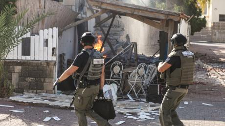 Israelische Soldaten gehen neben einem zerstörten Haus während eines Raketenangriffs aus Gaza. Die Israelin Romina hat unserer Redaktion geschildert, wie sie den Angriff der Hamas im Oktober erlebte. 