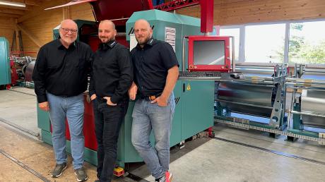 Zwei Generationen vereint: (von links) Klaus Frech und seine Söhne Sebastian und Patrick vor einer der modernsten Maschinen, die Blechverkleidungen und Dämmkissen verarbeitet.
