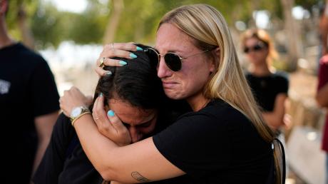 Menschen trauern während der Beerdigung eines israelischen Paares, das bei einem blutigen Angriff der Hamas auf Israel am vergangenen Samstag getötet worden war.  