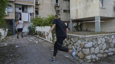 Wieder ein Angriff der Hamas: Hier rennen Israelis in Aschkelon, um Deckung zu suchen, als eine Sirene vor anfliegenden Raketen warnt.