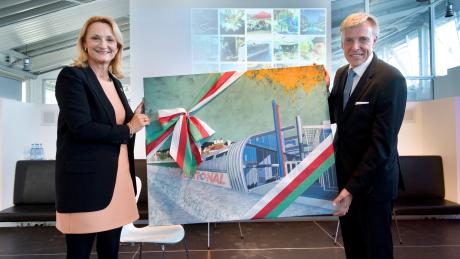 Oberbürgermeisterin  Doris Baumgartl überreicht das Jubiläumsgeschenk an Dr. Peter Stadelmann (Vorstandsvorsitzender). Das Bild wurde vom Landsberger Maler Hans Dietrich gemalt.