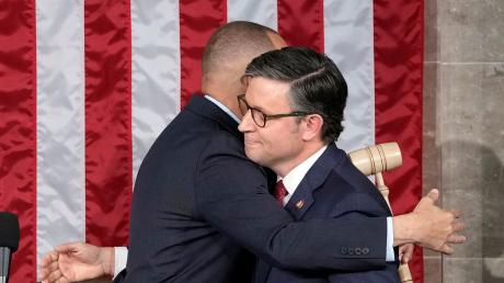 Hakeem Jeffries (l), Minderheitenführer im US-Repräsentantenhaus, umarmt Mike Johnson, neu gewählter Vorsitzender des US-Repräsentantenhauses.