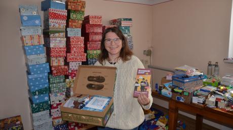 Hinter Carmen Graf aus Tiefenbach stapeln sich Weihnachtsgeschenke für bedürftige Kinder.