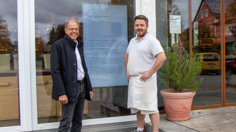Bürgermeister Andreas Scharf (links) und Wolfgang Immel, Inhaber der gleichnamigen Landbäckerei, präsentieren die seit Kurzem installierte und zentral gesteuerte Informationstafel in Lagerlechfeld.