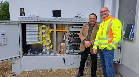 Glasfaserausbau in Ebershausen: Das Bild zeigt Bürgermeister Harald Lenz und Matthias Theisen von der Clevernet GmbH vor einem Verteilerkasten.