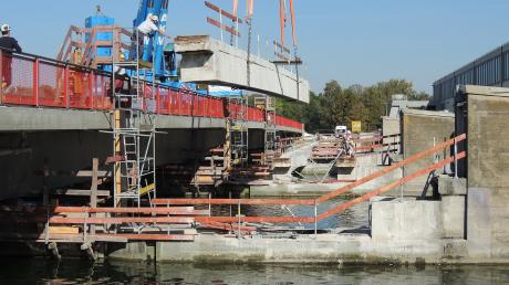 Eine Brücke wird zerstückelt: Ein Schwerkran hebt in Bertoldsheim die Teile der alten Kraftwerksbrücke heraus.