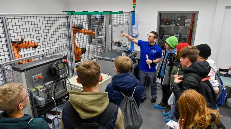 Beim Ausbildungstag bei der Firma Eichler in Pürgen interessierten sich die Teilnehmenden für die Robotik.  Ausbilder Richard Wegele (blaues T-Shirt) erklärte deb Arbeitsablauf.