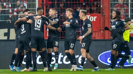 Ermedin Demirovic (verdeckt) vom FC Augsburg bejubelt sein Tor zum 0:1 durch einen Elfmeter mit der Mannschaft. 