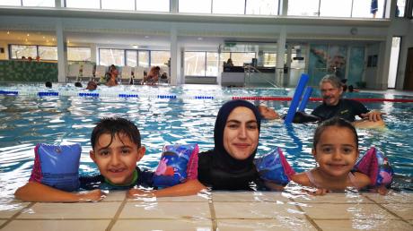 Ehsan Al-Amin und ihre Kinder genießen die Zeit im Lechtalbad in Kaufering. Möglich macht es ein Schwimmkurs für Migrantinnen. Im Hintergrund ist Schwimmlehrer Karsten Schubert mit einer weiteren Kursteilnehmerin zu sehen.