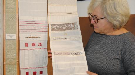 Corinna Kammerer zeigt die Mustertücher, die im Handarbeitsunterricht entstanden.
