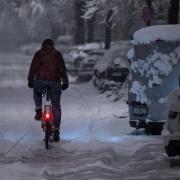 01.12.2023, Bayern, München: Ein Mann fährt mit seinem Fahrrad über eine schneebedeckte Straße. Foto: Sven Hoppe/dpa +++ dpa-Bildfunk +++