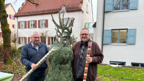 Gemeindereferent Michael Hahn und Pfarrer Rupert Ostermayer (von links) haben bereits einen Christbaum und Schmuck für den Heiligabend im Pfarrsaal besorgt.