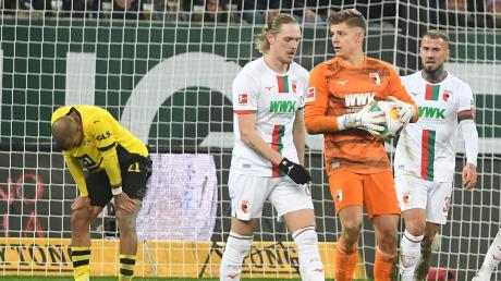 FCA-Torhüter Finn Dahmen hat wieder mal den Ball, der Dortmunder Donyell Malen (links) kann es nicht fassen.