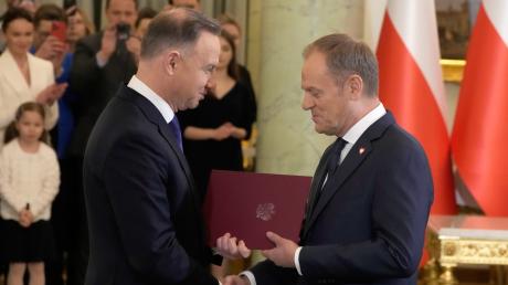 Das Lächeln der Rivalen: Präsident Andrzej Duda und der Ministerpräsident Donald Tusk bei der Vereidigung. PiS-Politiker Duda könnte der neuen Regierung durch sein Vetorecht das Leben schwer machen. 