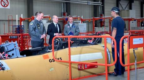 Bundeskanzler Olaf Scholz war zu Besuch bei Airbus Defence and Space in Manching. Auf dem Foto spricht er mit einem Mitarbeiter in der Endmontagehalle des Eurofighters.