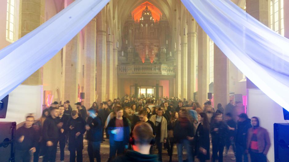 Menschen tanzen in der Predigerkirche beim Techno-Rave "Rave like God". Mit dem für Thüringen ungewöhnlichem Format will die evangelische Predigergemeinde vor allem Menschen zwischen 25 und 35 Jahren ansprechen.