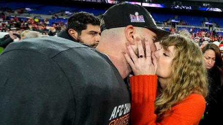 Die Musikerin Taylor Swift küsst Kansas City Chiefs Tight End Travis Kelce nach einem NFL-Footballspiel auf dem Spielfeld. Aufgeregte Debatten folgen.