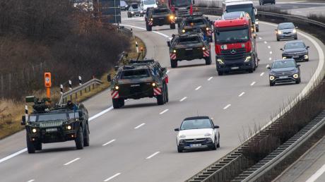 Fahrzeuge der Bundeswehr rollen im dichten Verkehr über die Autobahn A2 in Brandenburg. Sie sind auf dem Weg zur Übung "Quadriga 2024". 