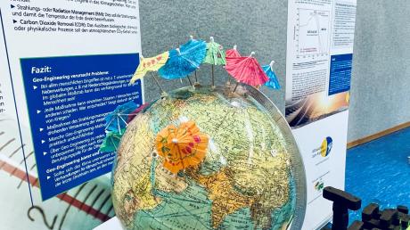 Das AEG in Oettingen will Klimaschule werden. In einer Ausstellung konnte sich die Schulfamilie nun über Ursachen des Klimawandels informieren. Auch Lösungen wurden aufgezeigt wie Beschattungen, was die Schirme auf dem Globus darstellen sollen.