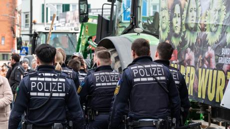 Polizisten gehen während einer Demonstration vor Beginn des politischen Aschermittwochs der Grünen vor der Stadthalle in Biberach. 